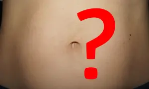 Brzuch z dużym czerwonym znakiem zapytania. Obfity okres, a jednak ciąża? Niepewność i pytania.
