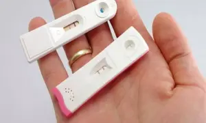 Dwa testy ciążowe w dłoni, oba pokazują jeden pasek - negatywny test ciążowy.