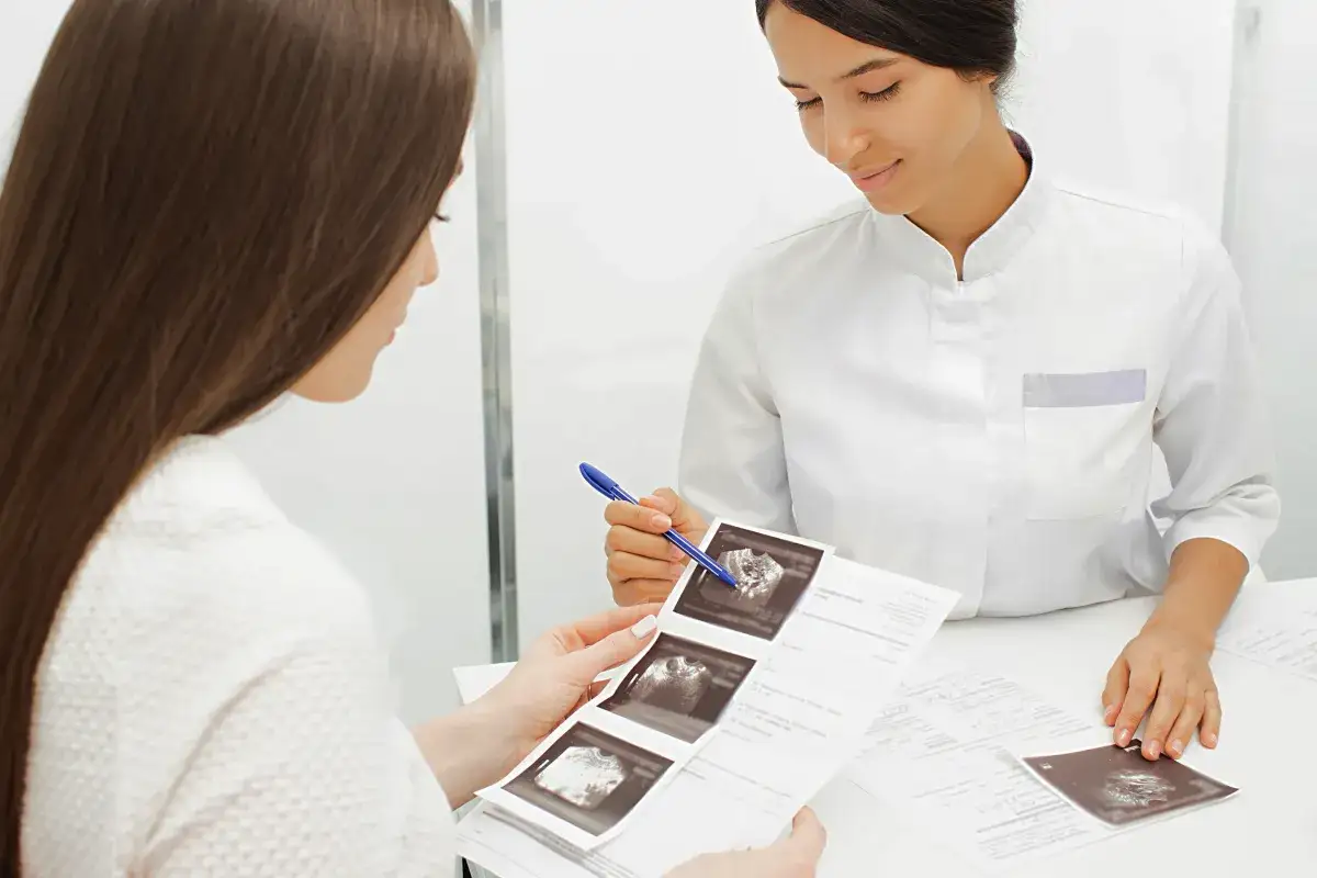 Lekarka omawia wyniki badań, w tym USG, z pacjentką. Pytanie, czy AMH może wzrosnąć, jest kluczowe w diagnostyce.