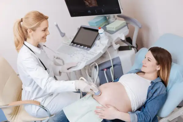 Lekarka wykonuje badanie USG ciężarnej. Na ekranie widać obraz płodu, a badanie to może pomóc określić, co oznacza bpd usg.