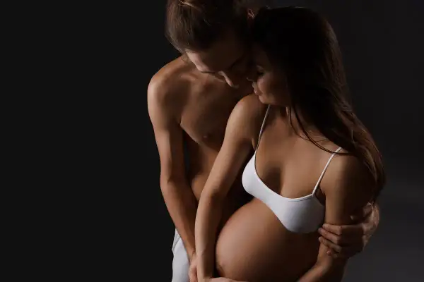 Para, obejmujący brzuch kobiety w ciąży. Czasem pojawia się brak ochoty na seks w ciąży, ale bliskość jest ważna.
