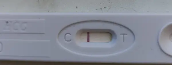 Test ciążowy z widocznym zarysem drugiej kreski. Czekam na cud.